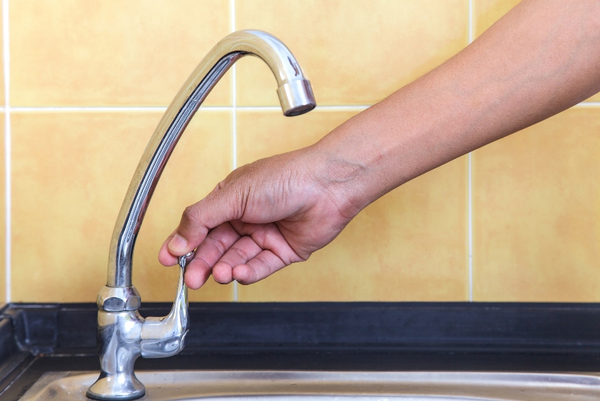 Person turning a tap on