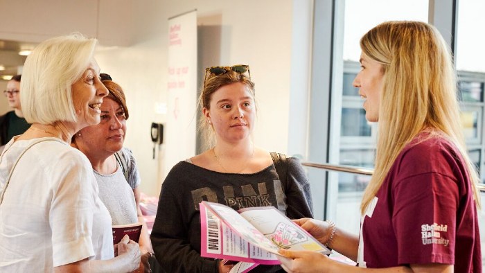 A prospective student and her family at a Sheffield Hallam open day, talking to an open day guide