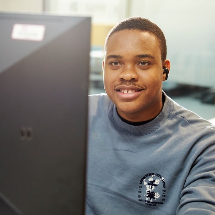A male student works at a computer.