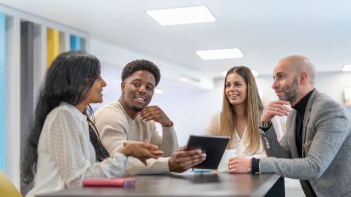 A group of students and academics sat around a table in friendly conversation