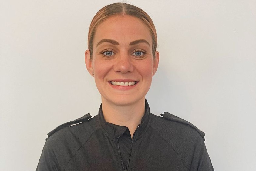 Ashleigh in police uniform smiling at camera.