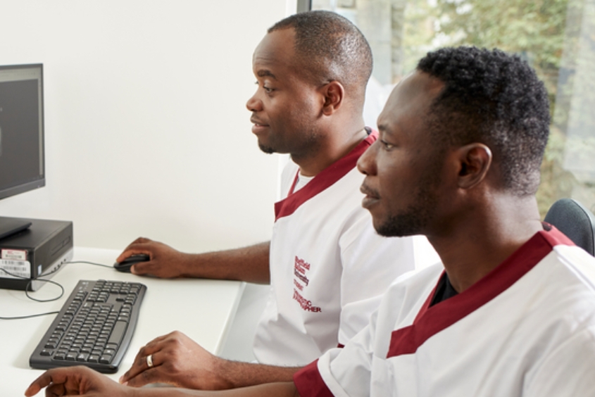 Two male health students sat at a computer