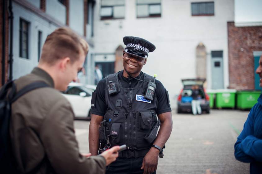 police officer smiling while talking to member of the  public.