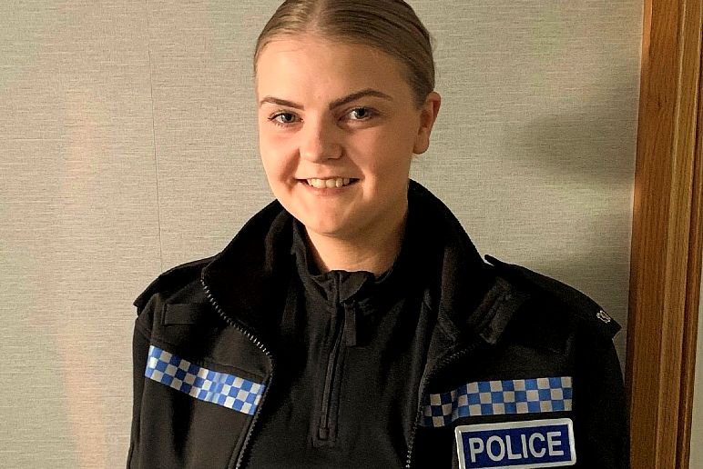 Sophie wearing police uniform smiling at the camera.