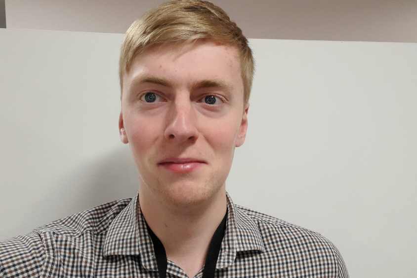 Headshot of male with blonde hair in a check shirt.