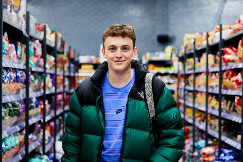 Student smiling facing camera in a supermarket 