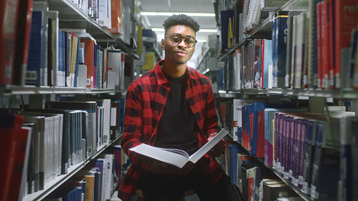 Student in a library with an open book
