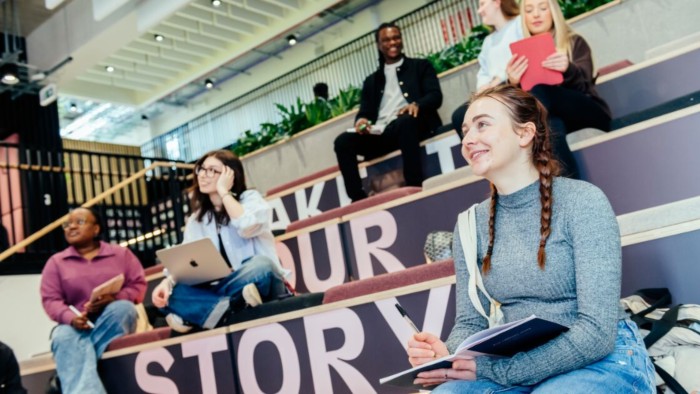 Several students sat on steps in a Sheffield Business School study area.