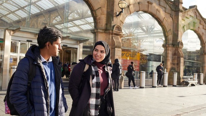 Two students in discussion leaving Sheffield Midland train station