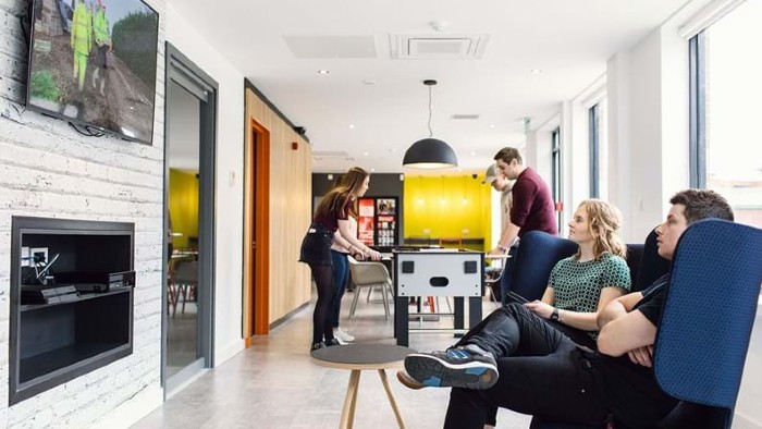Several residents relaxing in a common room at student halls