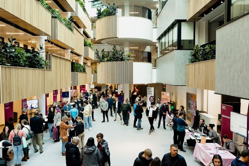 A gathering of attendees at an open day event in the Sheffield Hallam city campus atrium