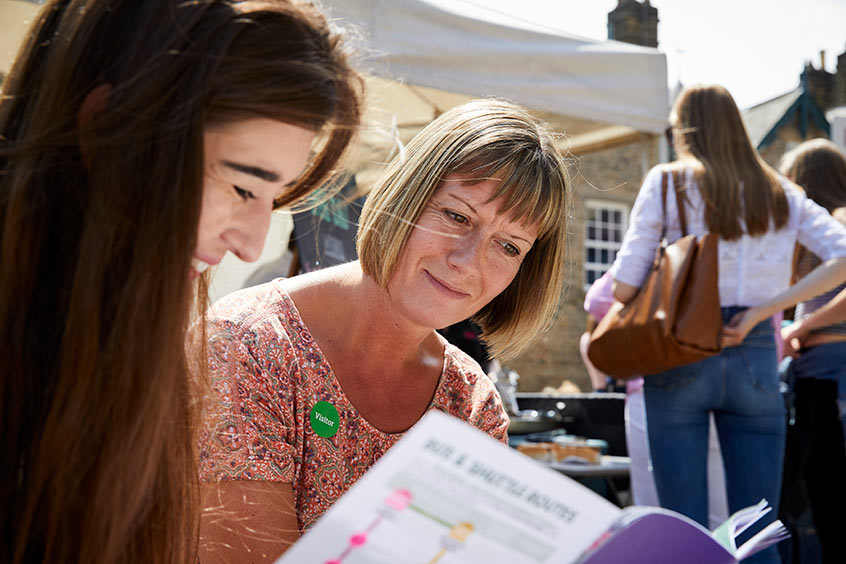 Two women reading an open day guide