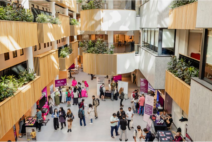 Students and staff at an open day in the atrium of the Sheffield Hallam Owen building