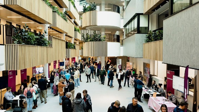 A crowd of attendees browsing stalls in the Sheffield Hallam atrium during an open day