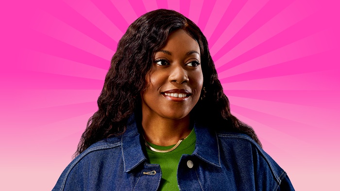 A female student with long hair and wearing a denim jacket, standing in front of a bright pink radiating background.