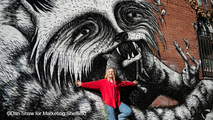 Student standing in front of street art in Sheffield