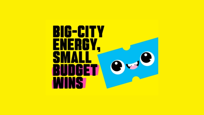Bright yellow background with the text 'big-city energy, small budget wins' over the top