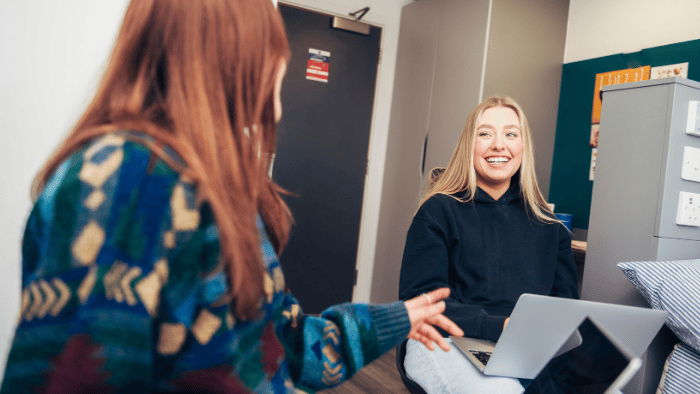 Two students chat while working together in Sheffield Hallam accommodation.