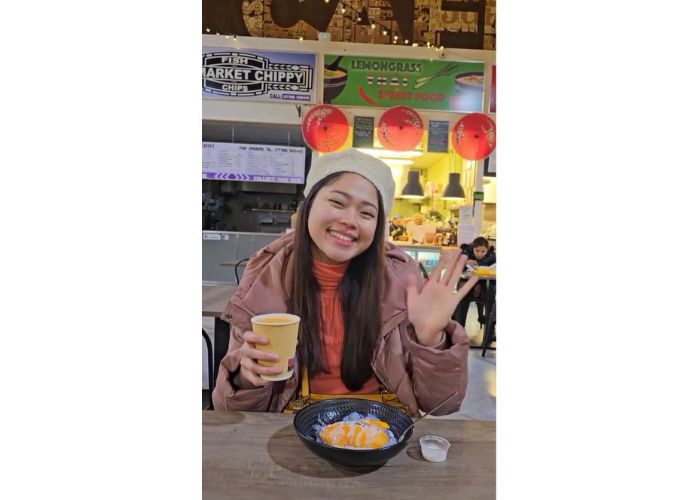 Student Darlene with a bowl of noodles and a hot drink