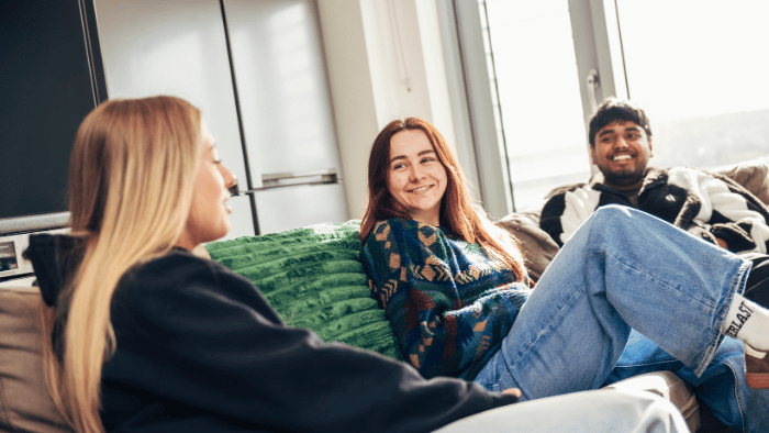 Three students relax in the social area of Sheffield Hallam accommodation.
