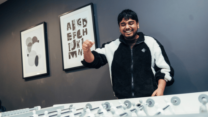 A Sheffield Hallam student celebrates while playing table football in University accommodation.