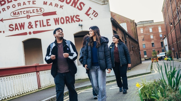 Group of young people walking to Sheffield Hallam campus, talking and smiling.