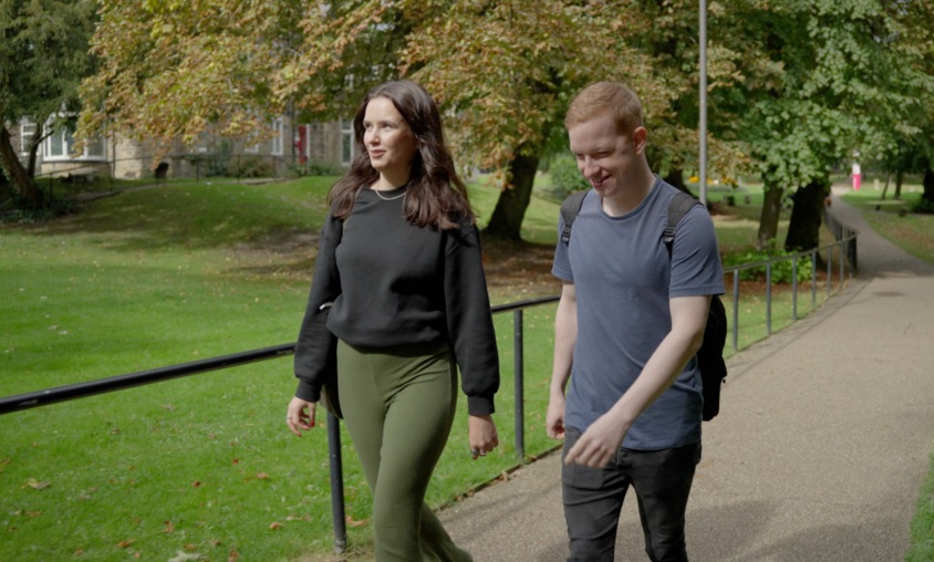 Jasmine and Tom walking together through Collegiate Campus