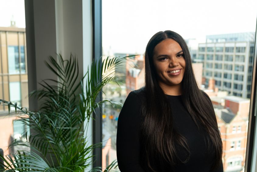 Katherine Green stood next to plant in office