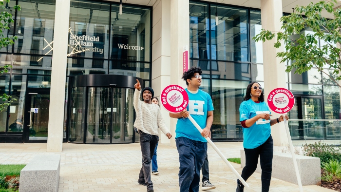 2 student ambassadors guiding a student on a student tour in front of Strines