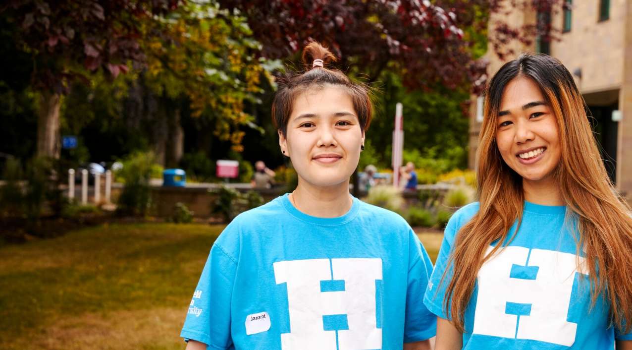 Two student ambassadors smiling, one with long hair and one with short hair.