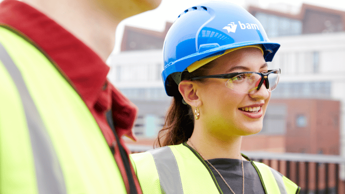 A Hallam student in a hi-vis jacket and a hard hat while on a visit to a BAM construction site.