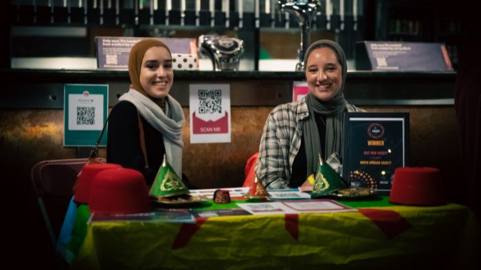 Four students holding together their beer glasses