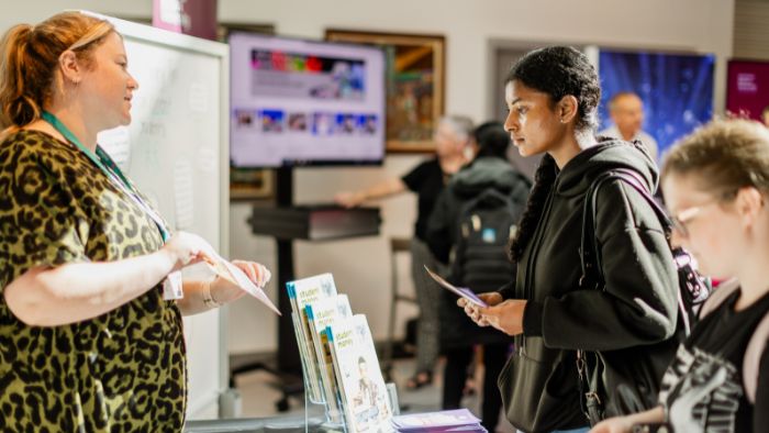 A student talking to a ui staff member at during Welcome activities.