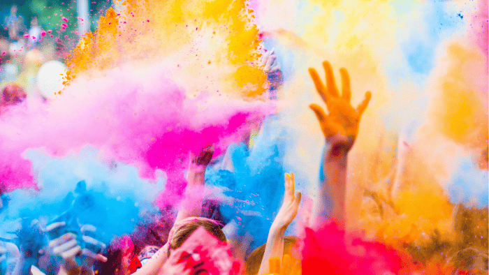 Image of coloured powder being splashed around at a festival