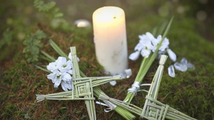 Image of a candle and some woven flowers