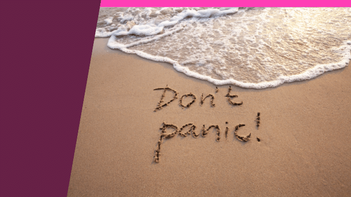 photo of the words dont panic on the sand, as a wave approaches
