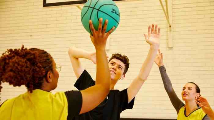 An image of people playing a game with a ball wearing coloured vests