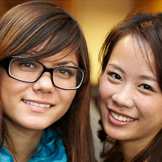 Two international students hugging at event